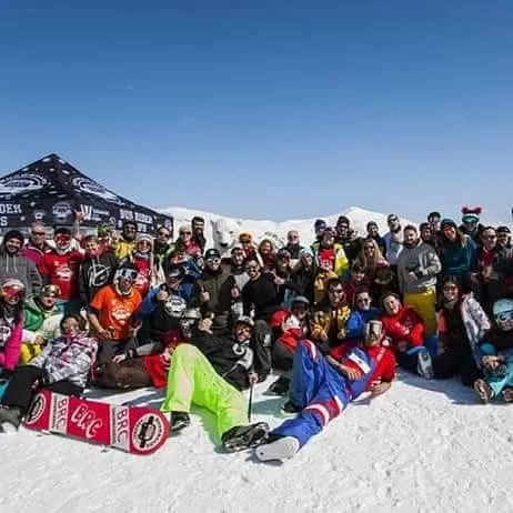 El grupo de Bus Rider Camps al completo en la nieve con las banderas